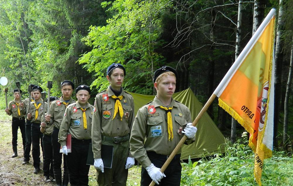 Скауты несут флаг в лесу