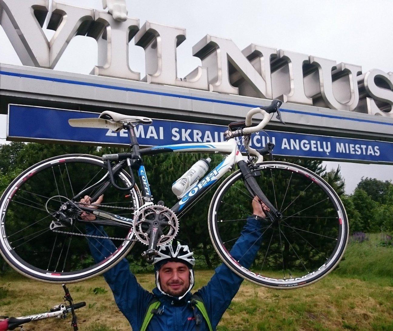 Велотурист держит велосипед в Европе в Вильнюсе