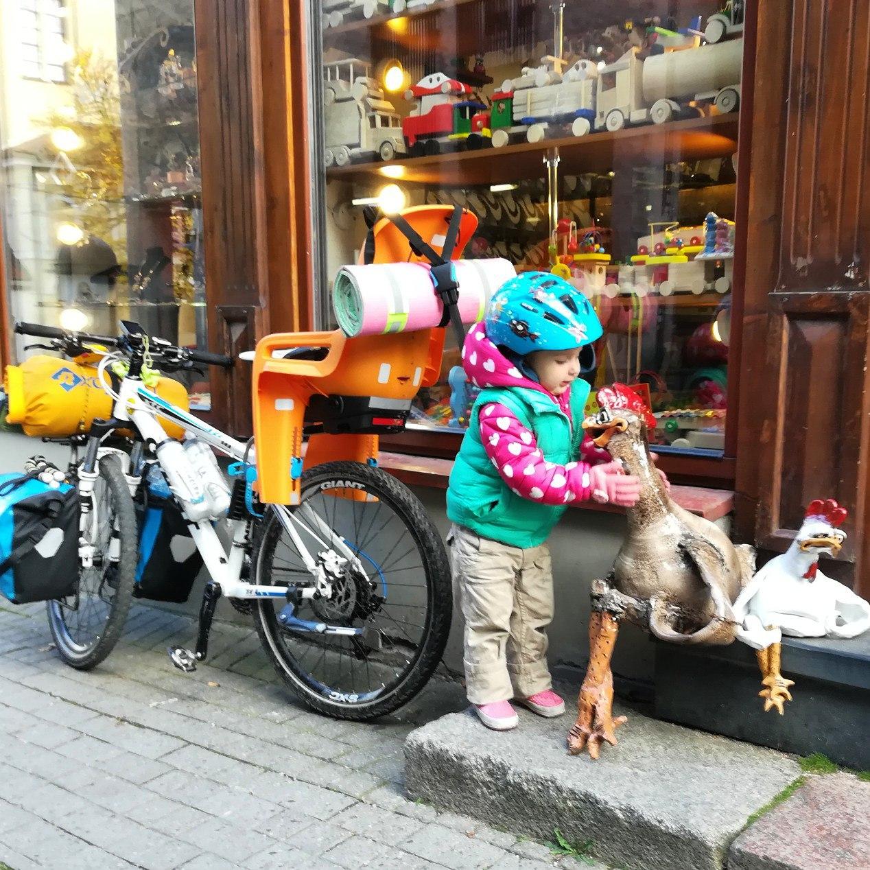 Девочка с велосипедом у магазина