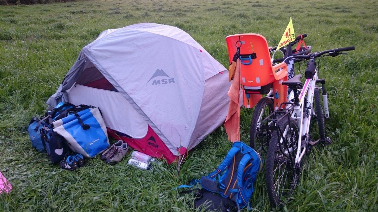 Велосипед и палатка в поле у туристов