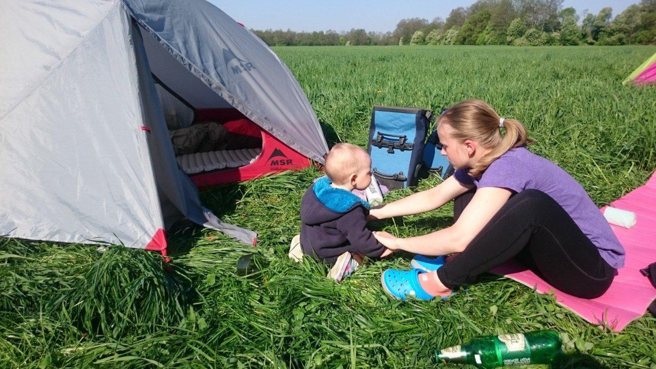 Веломама и ребенок у палатки в поле
