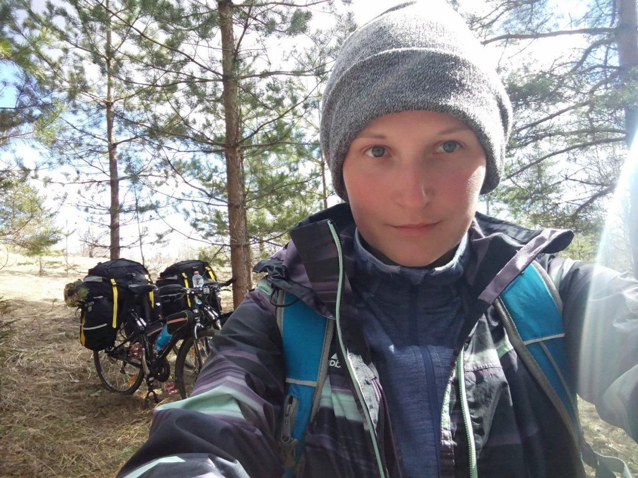 Путешественница в лесу с велосипедами и рюкзаками