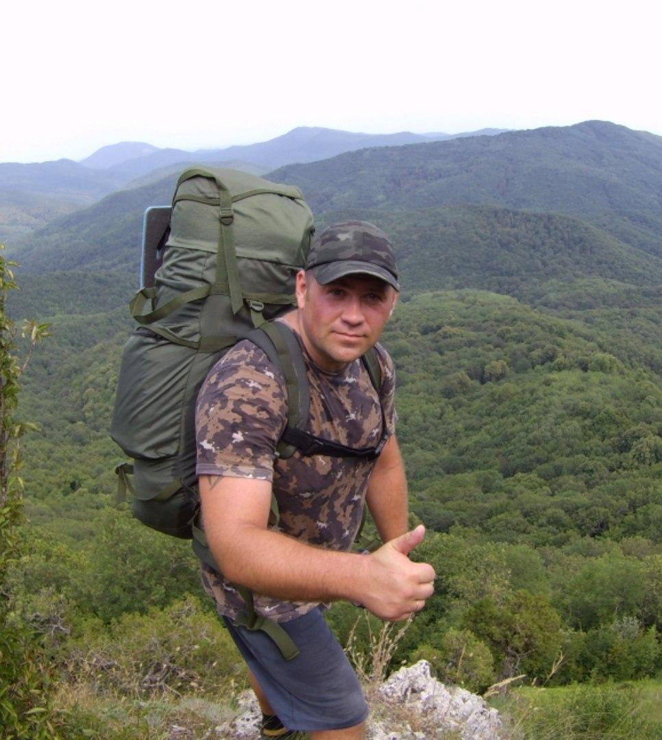Турист высоко в горах с большим рюкзаком