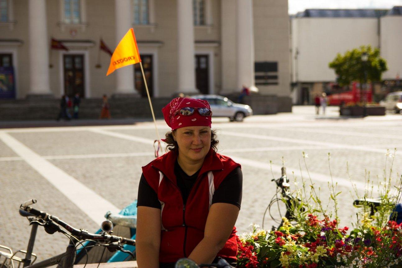 Женщина с велосипедом на фоне города