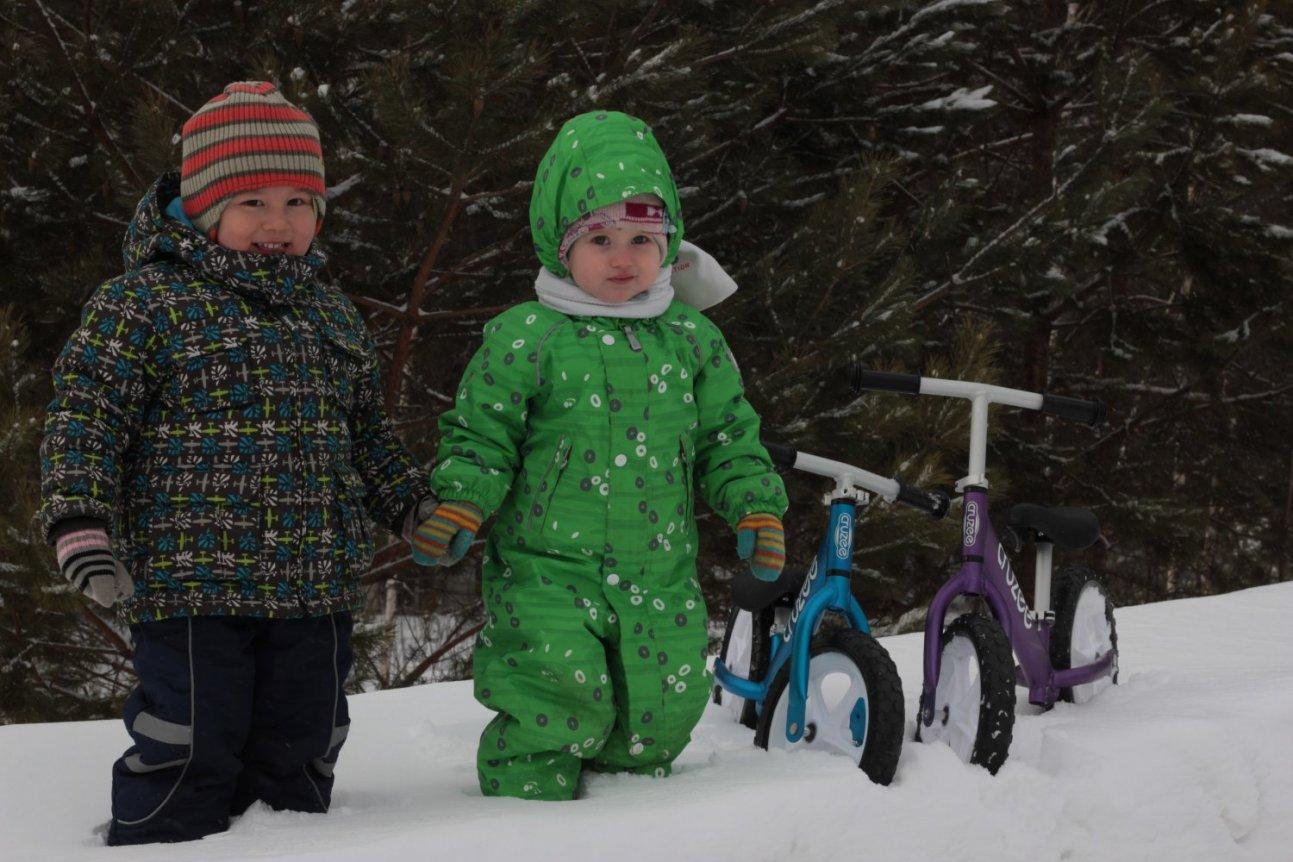 Дети зимой на снегу с велосипедами в лесу