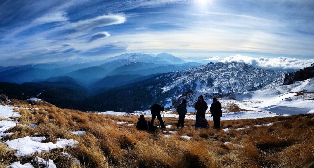Группа туристов в горах стоят на фоне красивых снежных гор