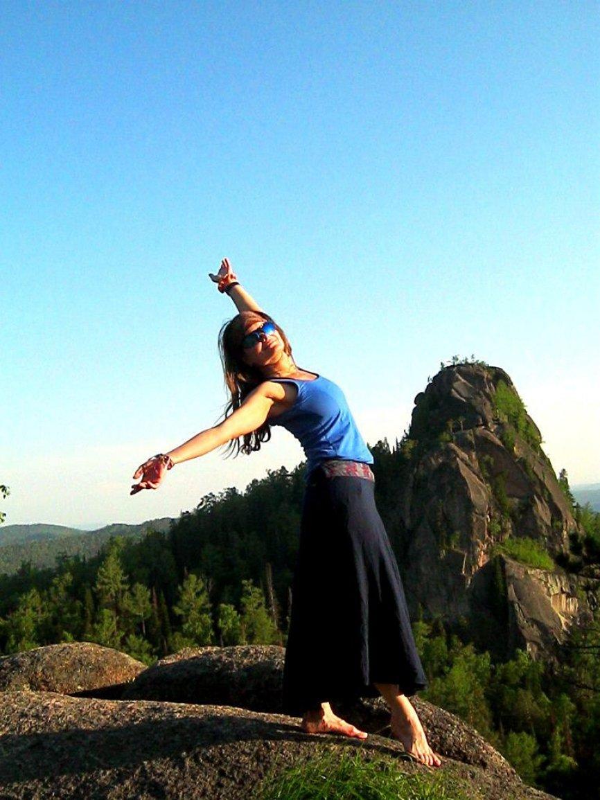 Девушка танцует в горах